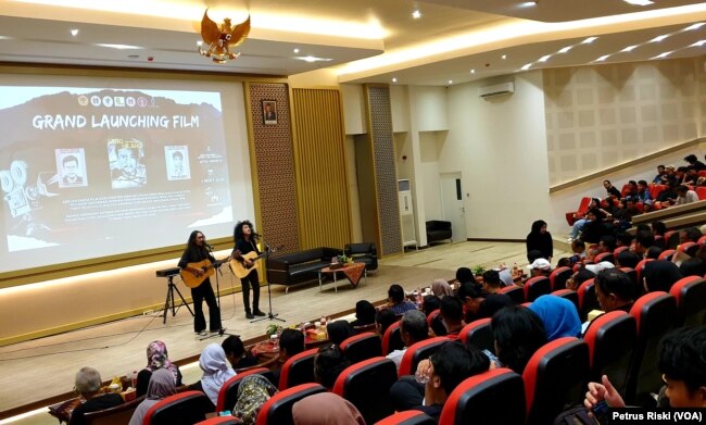 Dua musisi membawakan lagu tentang hilangnya 13 mahasiswa saat Reformasi 1998, di awal pemutaran film Yang (Tak Pernah) Hilang. (VOA/Petrus Riski)