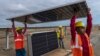 Workers carry a solar panel for installation at the under-construction Adani Green Energy Limited's Renewable Energy Park in the salt desert of Karim Shahi village. (AP Photo/Rafiq Maqbool)
