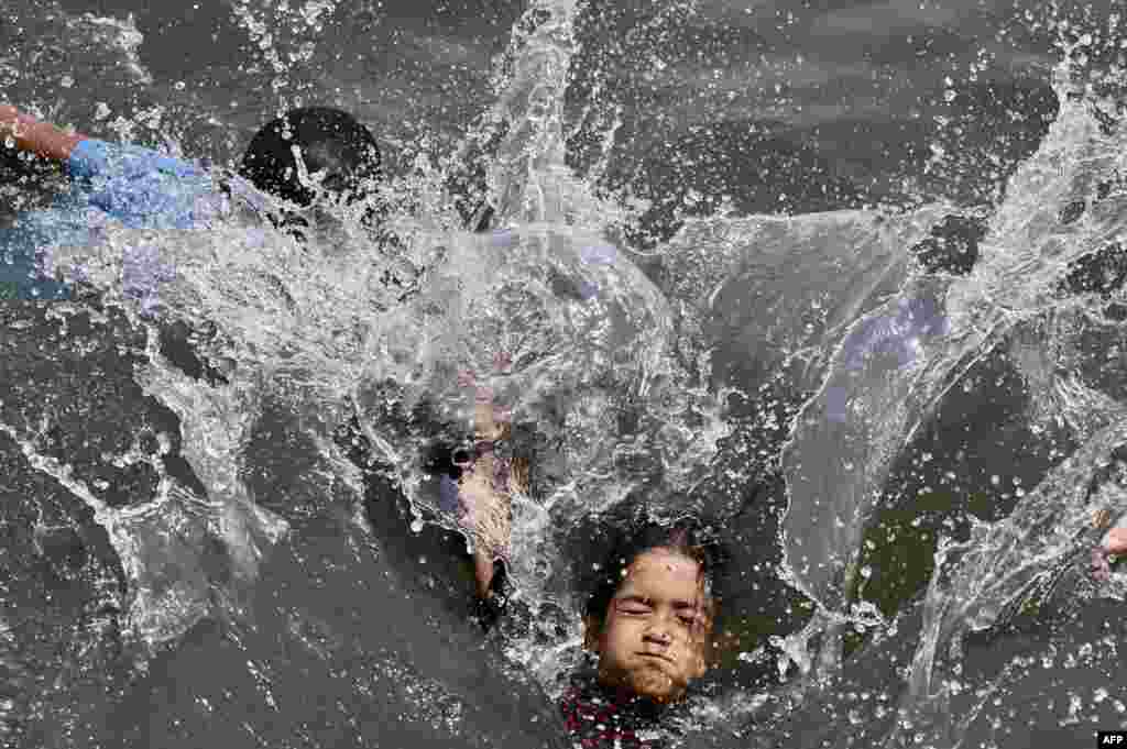 Children swim in the Buriganga River in Dhaka, Bangladesh.