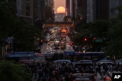 En julio próximo, los que lleguen a Nueva York podrán captar el momento en que el sol se pone entre los edificios de Manhattan. [Footgrafía de AP, el martes 30 de mayo de 2023. (Foto AP/Yuki Iwamura)