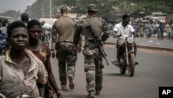 FILE - French army military instructors walk on one of the main roads in Tanguietan, northern Benin, March 28, 2022. (AP Photo/ Marco Simoncelli, File)