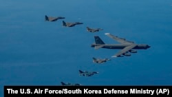 A U.S. Air Force B-52H bomber, center, F-16 fighter jets, South Korean Air Force F-15K fighter jets, left top, and Japanese Air Force F-2 fighter jets, left bottom, fly in formation during a joint air drill near Korean Peninsula, Oct. 22, 2023. 
