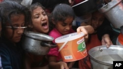 Sejumlah anak-anak Palestina tampak mengantre untuk mendapatkan makanan di wilayah Rafah, Jalur Gaza, di tengah serangan pasukan Israel yang terus berlangsung pada 13 November 2023. (Foto: AP/Hatem Ali)