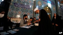A cleric receives his ballot paper during parliamentary and Assembly of Experts elections at a polling station in Tehran, Iran, March 1, 2024.