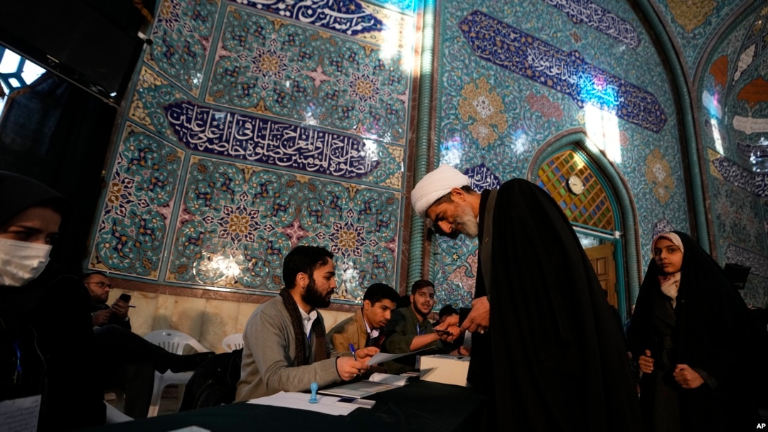 Seorang ulama menerima surat suara ketika menggunakan hak pilihnya dalam pemilu parlemen dan Majelis Ahli Iran, di sebuah tempat pemungutan suara di Teheran, pada 1 Maret 2024. (Foto: AP/Vahid Salemi)