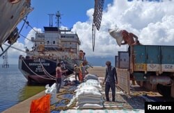 Para pekerja memuat kiriman beras di pelabuhan ekspor beras utama di Pelabuhan Kakinada di negara bagian Andhra Pradesh, di selatan India, 2 September 2021. (Foto: Rajendra Jadhav/Reuters)