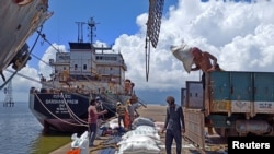 FILE - Laborers unload rice bags from a supply truck at India's main rice port at Kakinada Anchorage in the southern state of Andhra Pradesh, India, Sept. 2, 2021. Picture taken September 2, 2021. 