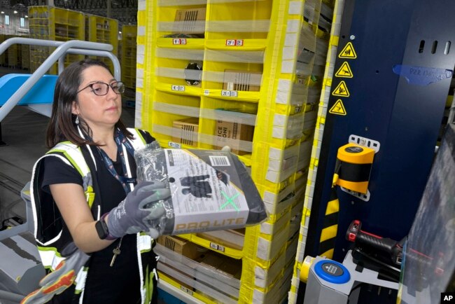 FILE - A worker moves a package at an Amazon same-day delivery shipping center in Woodland Park, New Jersey, Dec. 18, 2023.