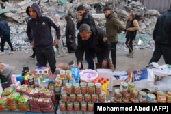 Warga Palestina berjalan melewati kios-kios yang didirikan di sebuah jalan di Rafah, di Jalur Gaza selatan, 10 Maret 2024, ketika umat Islam bersiap menyambut bulan Ramadan di tengah perang Israel dan Hamas. (Foto: AFP/Mohammed Abed)