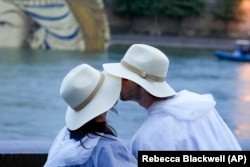 FILE - A couple kisses on the Seine in Paris, France, during the 2024 Summer Olympics, Friday, July 26, 2024. (AP Photo/Rebecca Blackwell, File)