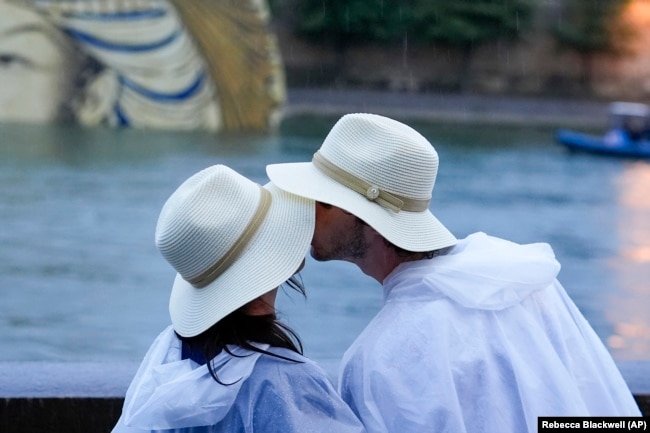 FILE - A couple kisses on the Seine in Paris, France, during the 2024 Summer Olympics, Friday, July 26, 2024. (AP Photo/Rebecca Blackwell, File)