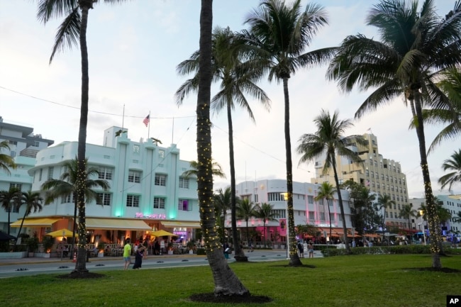 Pedestrians walk along Ocean Drive with its beautiful Art Deco buildings, Tuesday, Feb. 27, 2024, in Miami Beach, Fla. (AP Photo/Marta Lavandier)