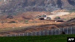A picture taken from southern Israel on the border with the Gaza Strip shows shows Israeli army vehicles driving on a road in Gaza on Jan. 18, 2024, amid the ongoing battles between Israel and the militant group Hamas.