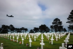 A plane flies over the American Cemetery in Colleville-sur-Mer, Normandy, June 5, 2023.