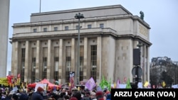 Paris'teki protesto gösterisine katılanlar tartışmalı göç yasasına karşı pankartlar taşıdı.