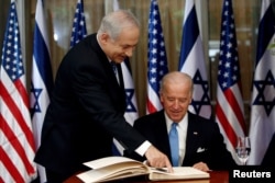 Joe Biden (kanan) yang saat itu menjabat sebagai Wakil Presiden AS bersiap menandatangani buku tamu sebelum bertemu dengan Perdana Menteri Israel Benjamin Netanyahu di kediaman Netanyahu di Yerusalem, 9 Maret 2010. (Foto: Reuters)