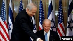 FILE - U.S. Vice President Joe Biden (R) prepares to sign the guest book before his meeting with Israel's Prime Minister Benjamin Netanyahu at Netanyahu's residence in Jerusalem March 9, 2010. 
