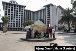 Warga berfoto di depan Masjid Agung Istiqlal, Jakarta, 31 Agustus 2024. (Foto: REUTERS/Ajeng Dinar Ulfiana)