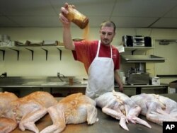 FILE - Final seasoning is spread on turduckens at the Gourmet Butcher Block at Gretna, Louisiana, Nov. 20, 2005. Turducken is part of a tradition known as engastration, a technique in which the remains of one animal are stuffed into another.