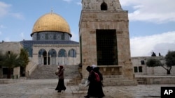 Jemaah Palestina berjalan melewati Kubah Batu di kompleks Masjid Al-Aqsa di Kota Tua Yerusalem, Senin, 19 Februari 2024. (AP/Maya Alleruzzo)