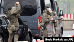 Heavily armed special police forces prepare for an operation at the airport in Hamburg, Germany, Nov. 5, 2023. An armed man is holding his four-year-old daughter at the airport. According to the police, the background to the attack is a custody dispute.
