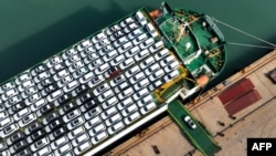This photo taken on December 5, 2023 shows cars being loaded onto a ship for export at the port in Lianyungang, in Chinas eastern Jiangsu province. (Photo by AFP) 