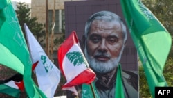 Potret pemimpin Hamas yang terbunuh, Ismail Haniyeh, dipajang dalam demonstrasi yang mengecam pembunuhannya di kota pesisir Sidon, Lebanon, pada 2 Agustus 2024. (Foto: AFP)