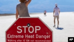 FILE - A person wipes sweat from their brow at Badwater Basin in Death Valley National Park, California, July 7, 2024.