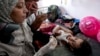 A health worker administers a polio vaccine to a child at a hospital in Khan Younis, Aug. 31, 2024. 