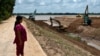 FILE - This photo taken July 9, 2024, shows villager Sok Rom looking at excavators being used on the construction of the Funan Techo Canal along the Prek Takeo channel in Kandal province. 