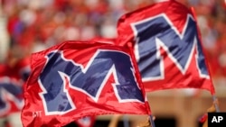 FILE - The University of Mississippi's school banner is waved during the pregame activities prior to the start of an NCAA college football game against LSU in Oxford, Miss., Oct. 23, 2021.
