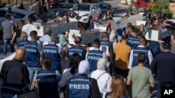 FILE - Palestinian journalists transportation  mock coffins of colleagues killed during the existent   Israel-Hamas war, during a symbolic ceremonial   procession successful  the West Bank metropolis  of Ramallah, Nov. 7, 2023.