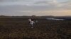 Una familia camina sobre el seco río Santa Lucía en el embalse Paso Severino en Florida, Uruguay, el martes 4 de julio de 2023.