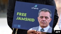 FILE - A demonstrator holds a picture of Jamshid Sharmahd, who has been sentenced to death in Iran, during a demonstration for his release in front of the German Foreign Ministry in Berlin, July 31, 2023.