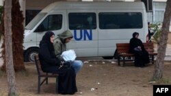 Displaced Palestinian people sit on benches as they wait outside a clinic of the United Nations Relief and Works Agency for Palestine Refugees in Rafah in the southern Gaza Strip on Jan. 28, 2024.