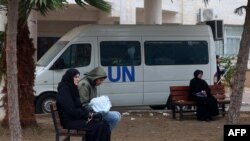 2024年1月28日，流离失所的巴勒斯坦人坐在长椅上，在加沙地带南部拉法的联合国援助机构的诊所外等候。（法新社照片）