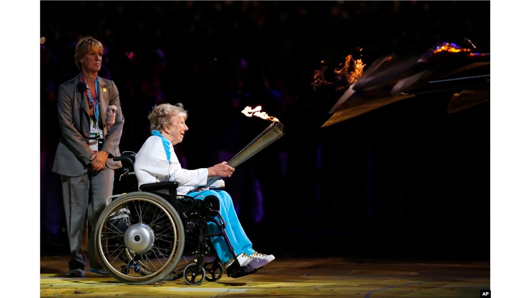 FILE - Margaret Maughan, Britain's first Paralympic gold medalist, lights the Paralympic flame during the Opening Ceremony for the 2012 Paralympics in London, Aug. 29, 2012.
