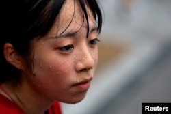 Rickshaw puller Yuka Akimoto, 21, sweats during her guide tour around the Asakusa district, Tokyo, Aug. 22, 2023. "I don't deny it was extremely hard at the beginning," she said, as the rickshaw can weigh up to 250 kg (551 lb). "I'm not athletic and the cart felt so heavy."