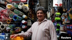 FILE - Guillermo Carnevale, 58, a supporter of Argentina's presidential candidate Javier Milei, poses for a photograph at his small hardware store, in Rio Gallegos, Argentina October 10, 2023.