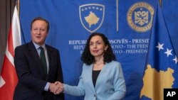 Presiden Kosovo Vjosa Osmani (kanan), menyambut Menteri Luar Negeri Inggris David Cameron di ibu kota Pristina selama kunjungan pertamanya ke Kosovo, Kamis, 4 Januari 2024. (AP Photo/Visar Kryeziu)