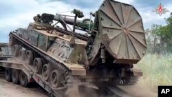 In this photo released by Russian Defense Ministry Press Service on Wednesday, July 12, 2023, an artillery system belonging to Russia's Wagner military contractor is put on a trailer at an undisclosed location.