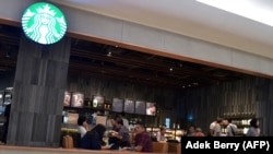 Para pengunjung menikmati kopi di sebuah kafe Starbucks di Jakarta, 4 Juli 2017. (Foto: Adek Berry/AFP)