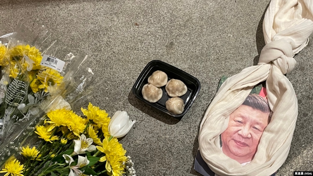 悼念李克强现场,习画像上套了一条围巾做的绞索和一盒包子。(周星晨)