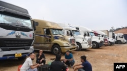 FILE - Truck drivers gather at a makeshift parking lot where Vietnamese container trucks are waiting to cross the Vietnam-China border in Lang Son province on Jan. 7, 2022.