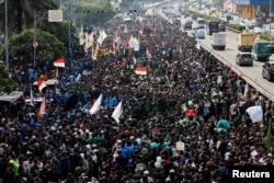 People gather outside the Indonesian Parliament building during a protest against planned controversial revisions to election law outside, in Jakarta, Indonesia, Aug. 22, 2024.