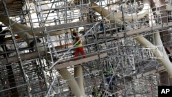 FILE - Laborers work on the Al Wasl Dome at the construction site of the Expo 2020 in Dubai, United Arab Emirates, on Oct. 8, 2019.