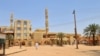 A few people walk outside Abdul Hayy mosque in Khartoum's Jabra neighborhood, on May 28, 2023, as many residents of the area have fled the ongoing fighting between two rival generals. 