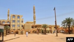 A few people walk outside Abdul Hayy mosque in Khartoum's Jabra neighborhood, on May 28, 2023, as many residents of the area have fled the ongoing fighting between two rival generals. 