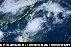 This satellite image taken by Himawari-8, a Japanese weather satellite and provided by the National Institute of Information and Communications Technology via AP, shows Typhoon Koinu, center, approaching Taiwan, Oct. 3, 2023.