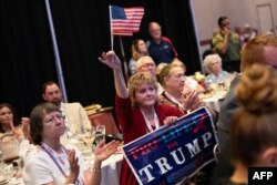 Seorang perempuan yang membawa poster pro-life (kelompok penentang aborsi) mendengarkan pidato mantan presiden AS, Donald Trump, di konvensi Partai Republik di Greensboro, Carolina Utara, Sabtu, 10 Juni 2023. (Foto: Allison Joyce/AFP)